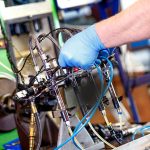Professional mechanic testing diesel injector in his workshop.